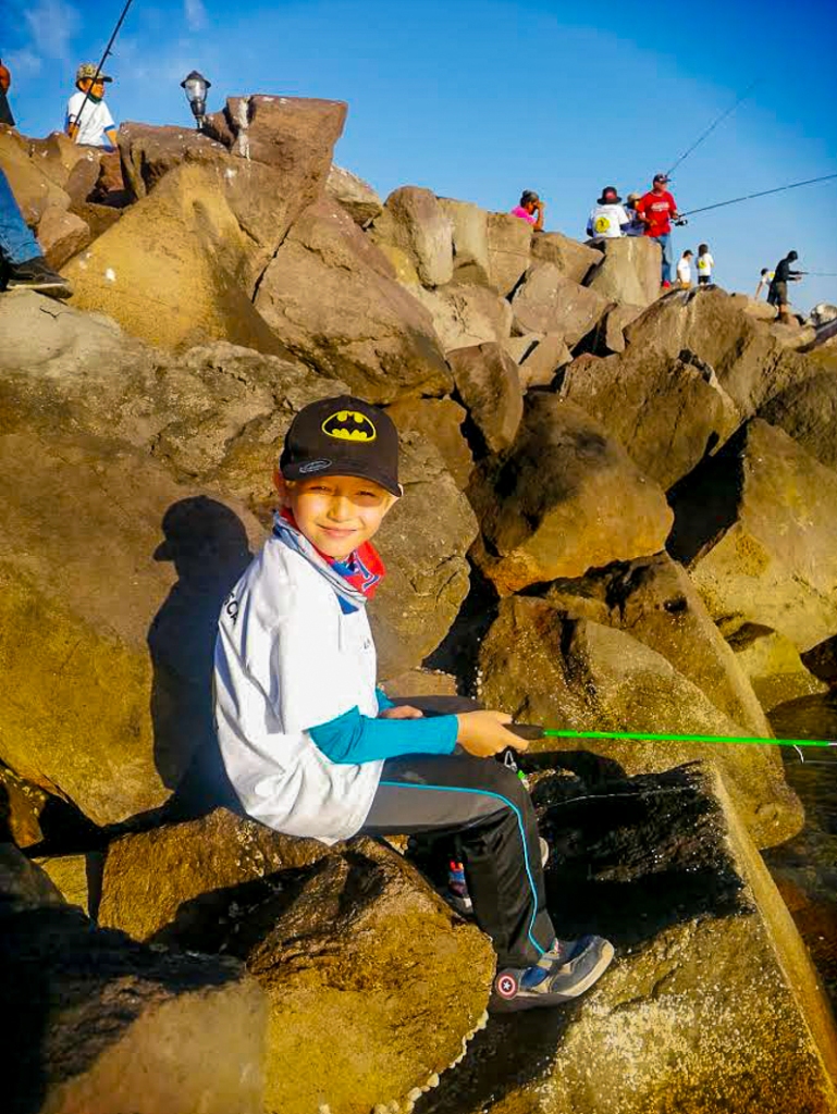 kid fishing on the rocks